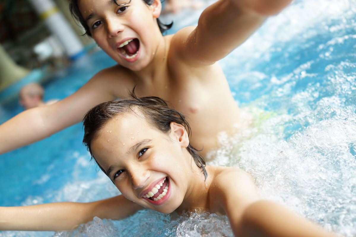 Twee jongens hebben plezier in het water van het zwembad